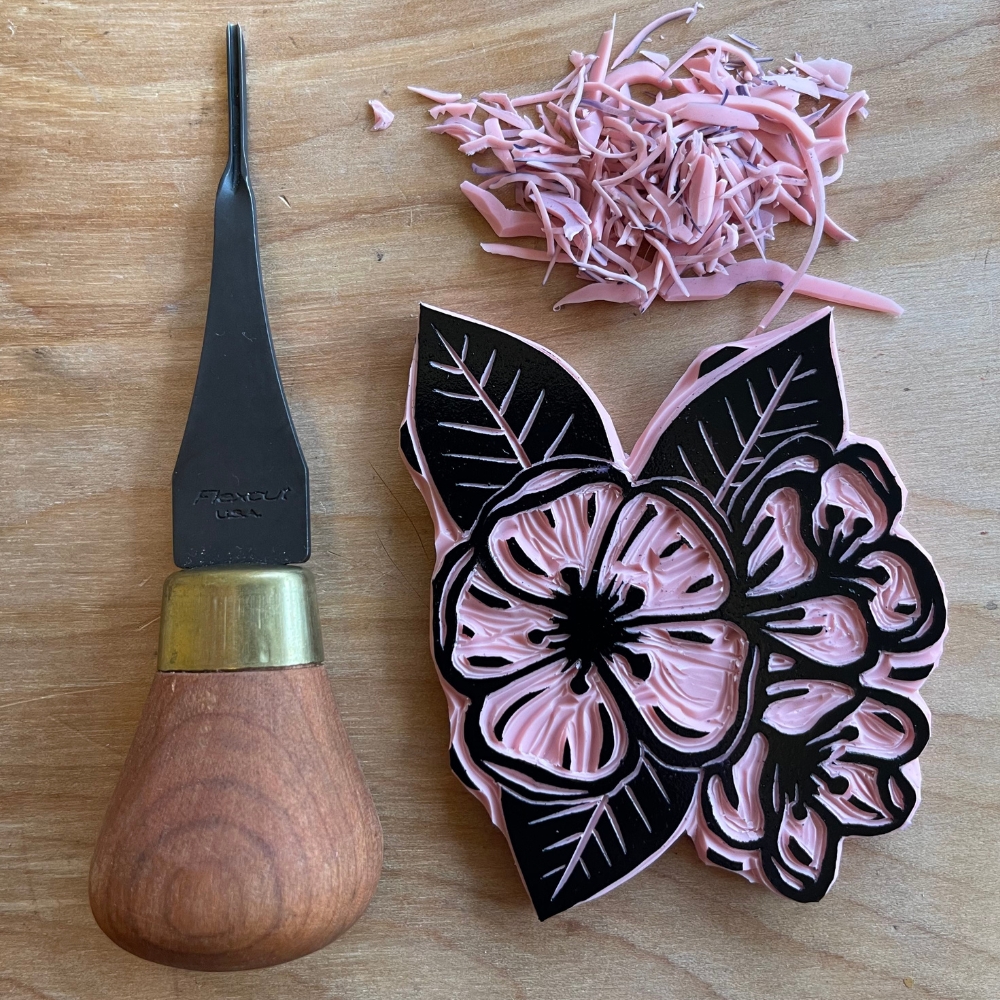 pink apple blossom flower carving with carving tool on wood table