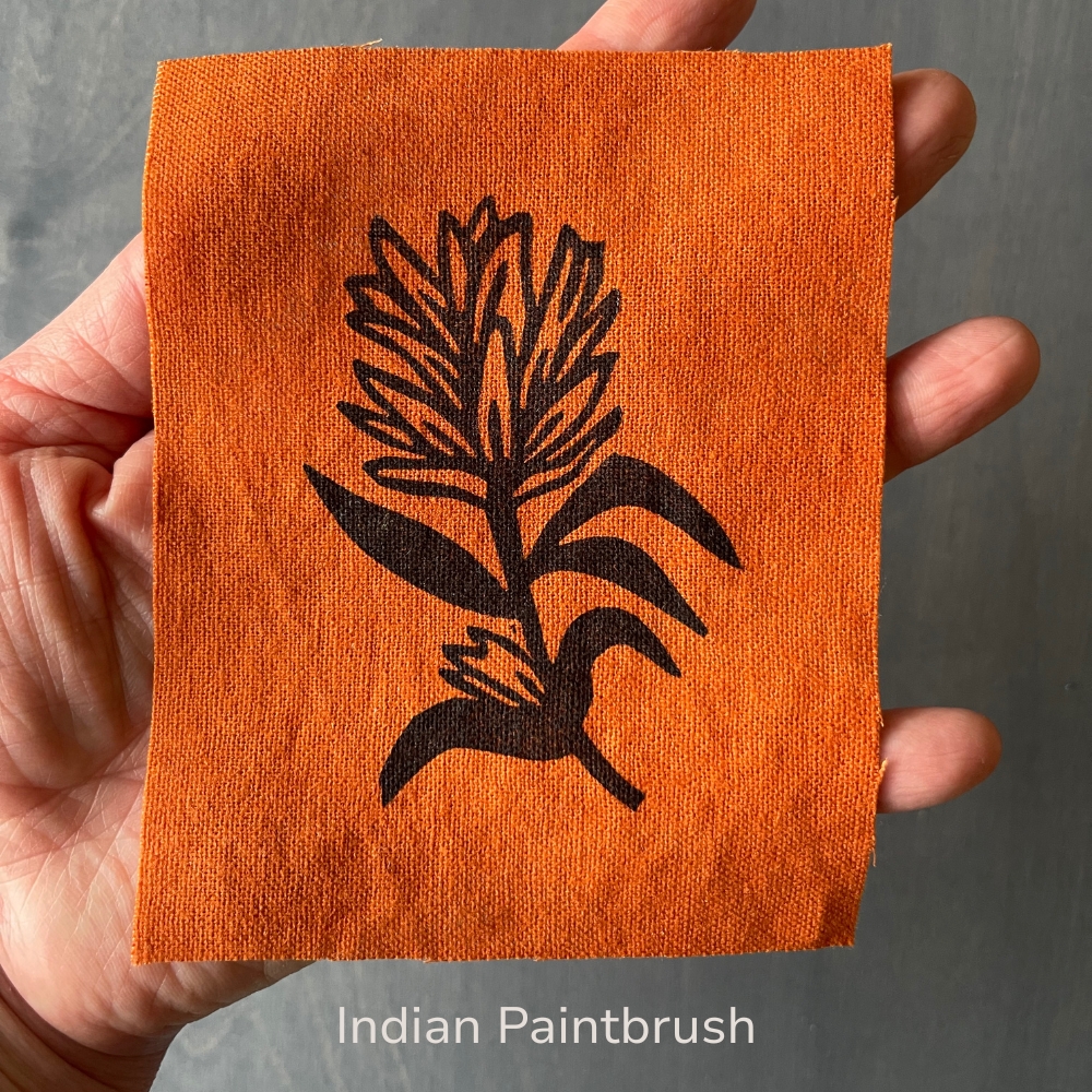 hand holding an orange indian paintbrush flower linen patch