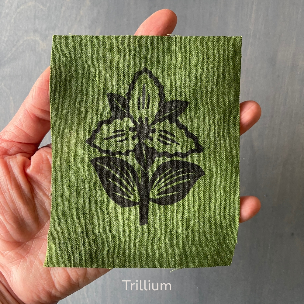 hand holding a green trillium flower linen patch